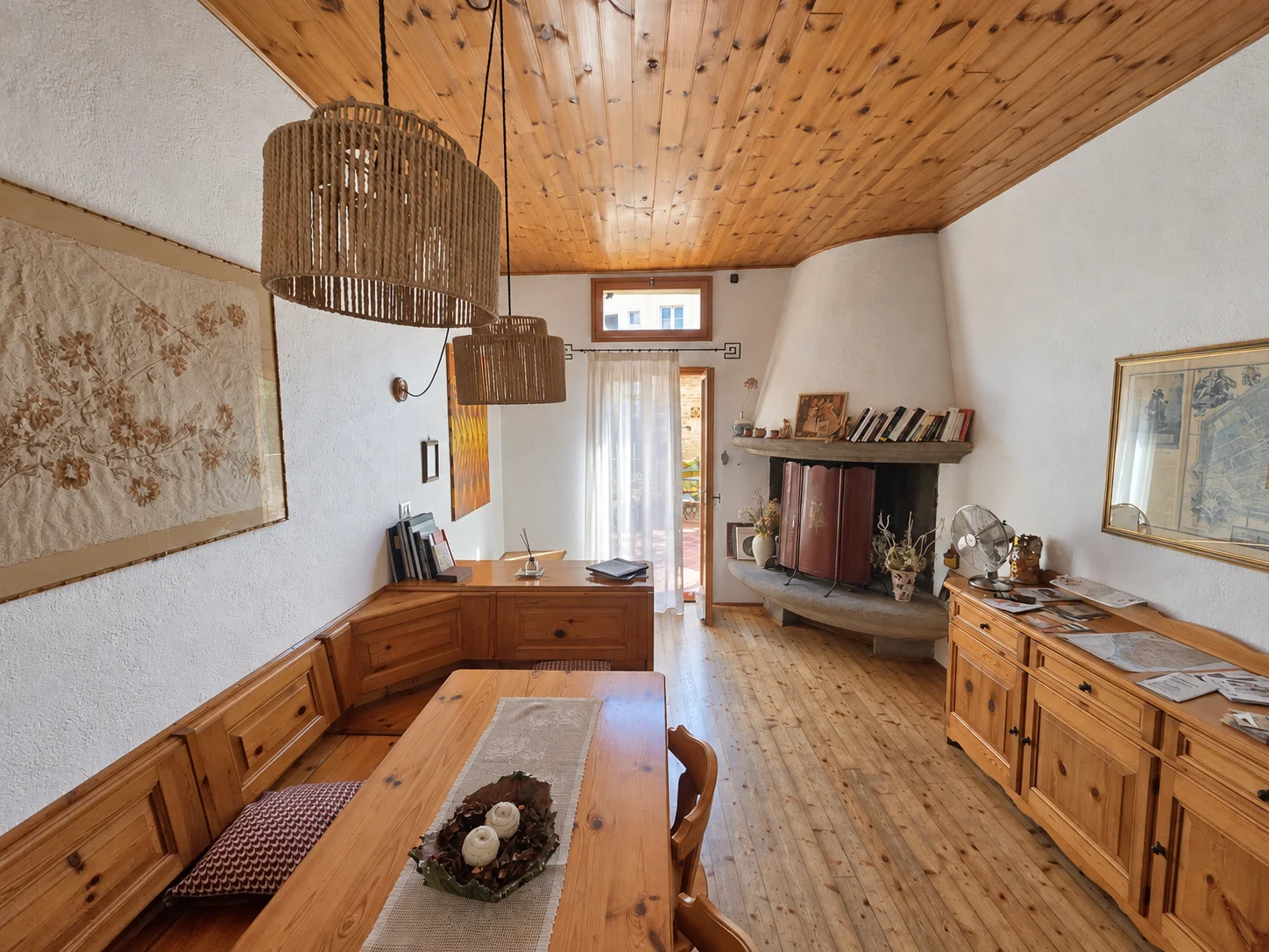 Sala comune con tavolo in legno e camino
